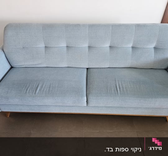ספה כחולה עם ריפוד בד על רצפת אריחים